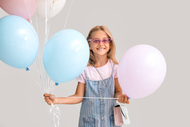 Девочка с воздушными шарами на сером фоне - Фото, изображение