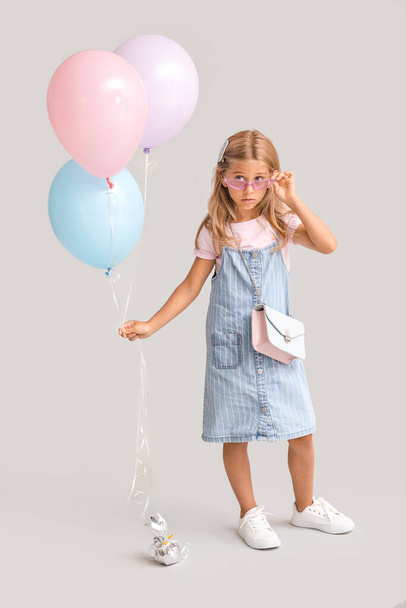 Menina surpreendida com balões em fundo cinza - Foto, Imagem