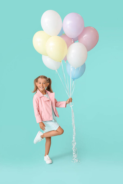 Little girl with balloons on color background - Fotó, kép