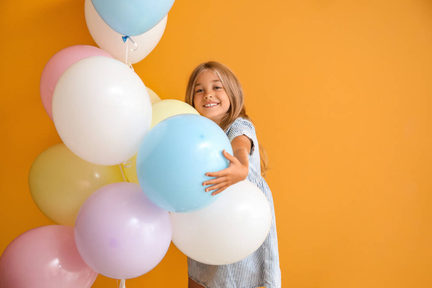 Little girl with balloons on color background - Fotografie, Obrázek