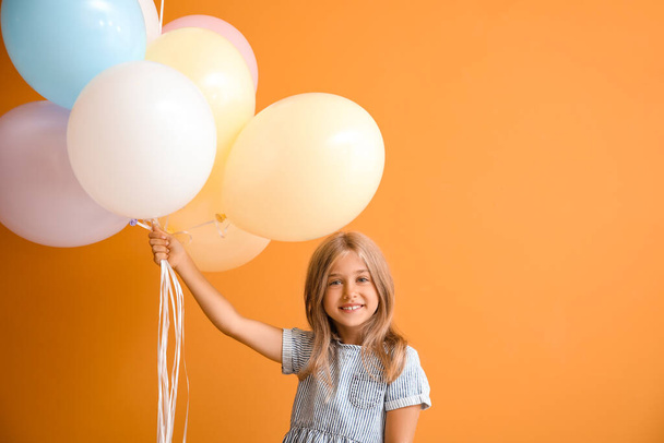 Kleines Mädchen mit Luftballons auf farbigem Hintergrund - Foto, Bild