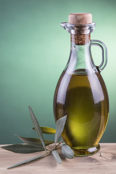 Olive oil bottle with green spotlight background - Foto, Imagen