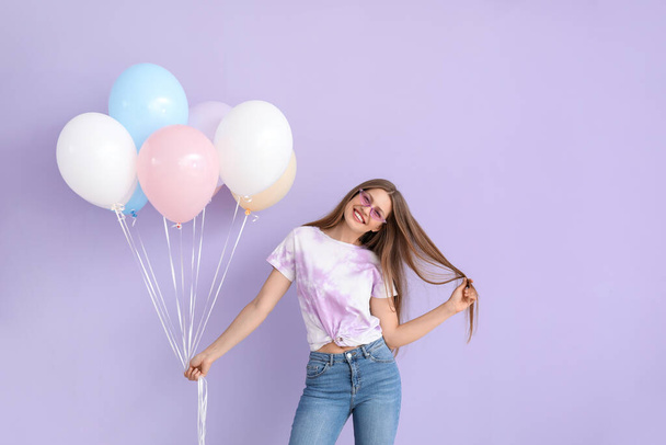 Young woman with balloons on color background - Foto, Imagem