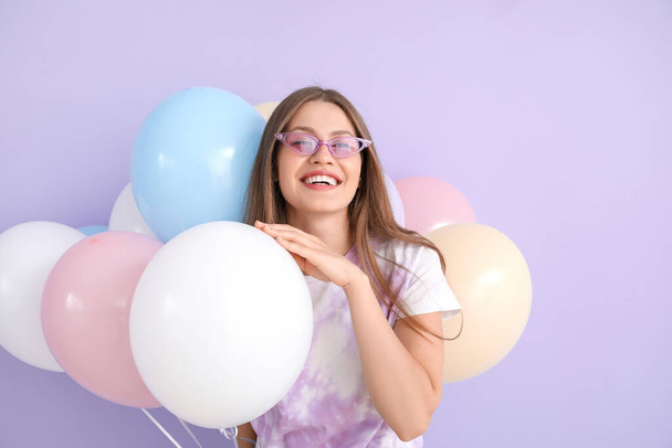 Young woman with balloons on color background - Fotoğraf, Görsel