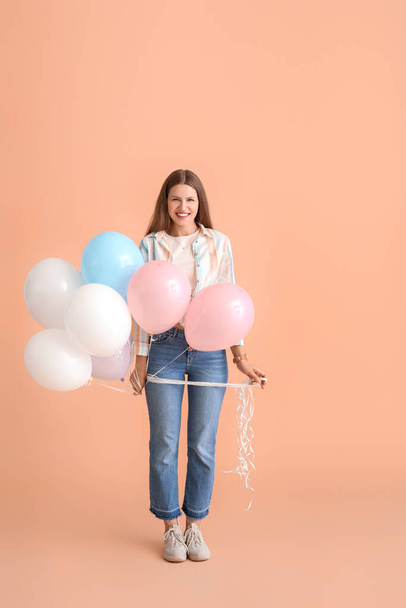 Young woman with balloons on color background - Фото, зображення