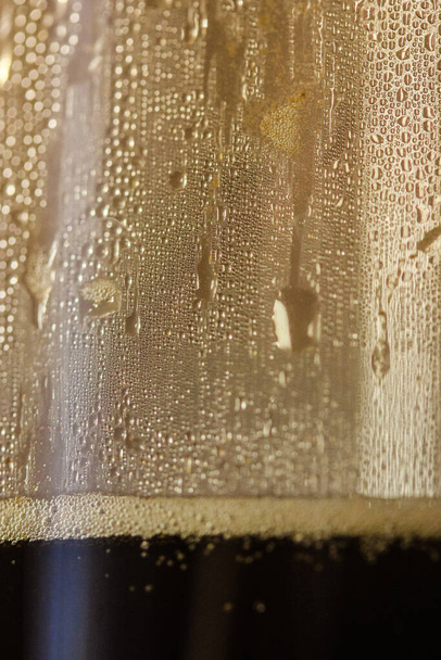 Kis arany cseppek az izzadt poháron: kávékészítés egy hangulatos őszi reggelen. - Fotó, kép