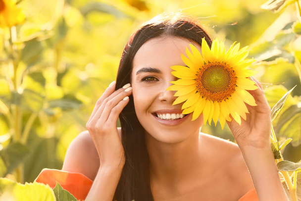 schöne junge Frau im Sonnenblumenfeld - Foto, Bild