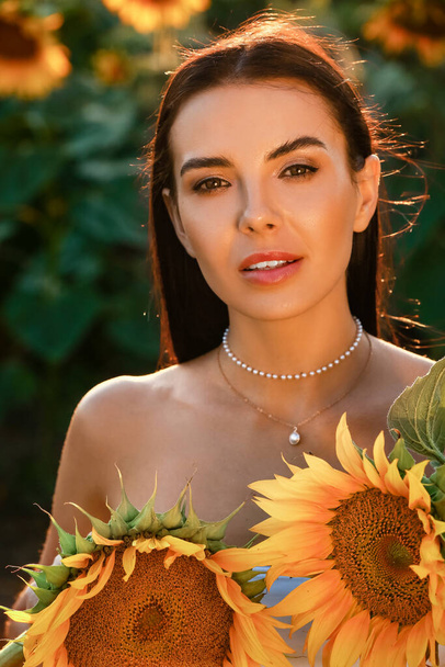 Beautiful young woman in sunflower field - Photo, image