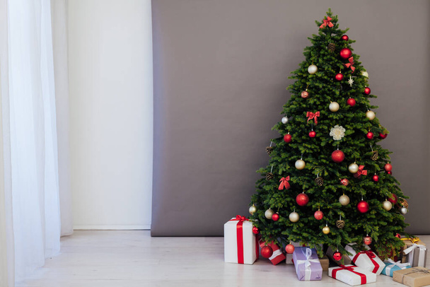 Het interieur van de kamer is een groene kerstboom met rode geschenken voor het nieuwe jaar decor van de wintervakantie - Foto, afbeelding