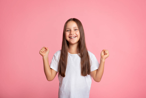 Эмоции счастья и победы. Маленький ребенок выражает радость и поднимает кулаки - Фото, изображение