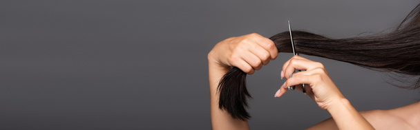 ostříhaný pohled na nahé brunetky žena stříhání vlasy izolované na černé, panoramatický záběr - Fotografie, Obrázek