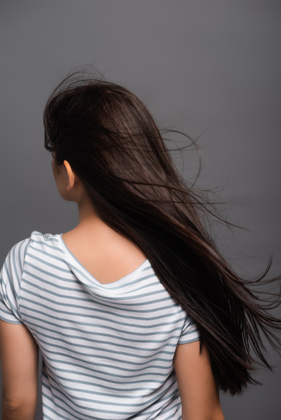 back view of wind blowing through hair of brunette woman isolated on black - Fotoğraf, Görsel