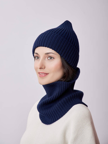A beautiful woman in an autumn hat and a Snood scarf on a white background. Autumn warm clothing - Foto, Imagem