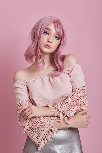 Portrait of a sexy young woman with pink hair. Perfect hairstyle and hair coloring. Girl with beautiful blue eyes and long pink hair - Foto, immagini