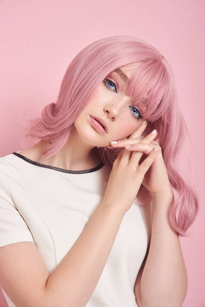 Cute girl with long pink hair, hair coloring. Beautiful woman on a pink background in a white dress. Colored hair, perfect hairstyle, beauty and care - Φωτογραφία, εικόνα