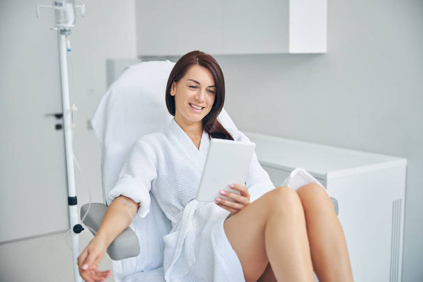 Pleased female patient using a tablet computer - Fotó, kép