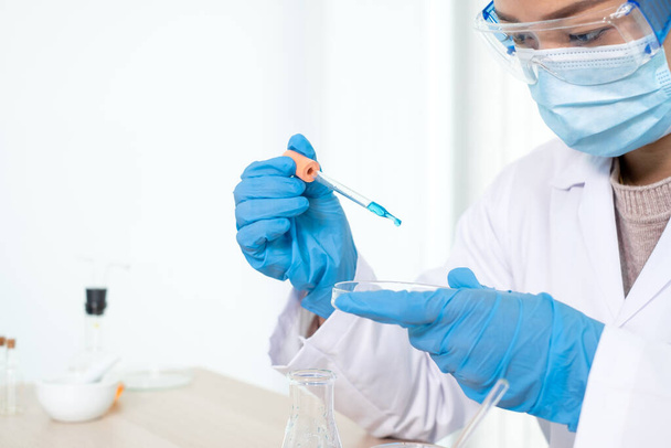 Medische wetenschappers brachten een monster in pipet in testglaswerk om het virus te analyseren in een chemisch laboratorium. Begrippen wetenschappelijk onderzoek. - Foto, afbeelding