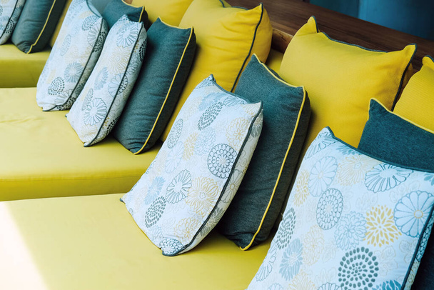 Close-up van gele stof bank en kussens versieren in tropische resort - Foto, afbeelding