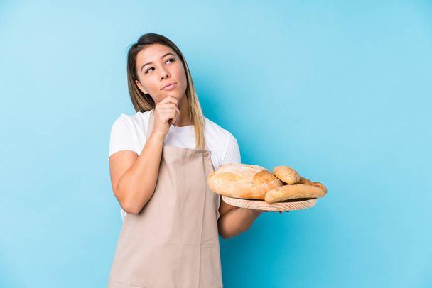 Young caucasian baker woman isolated looking sideways with doubtful and skeptical expression. - Foto, immagini