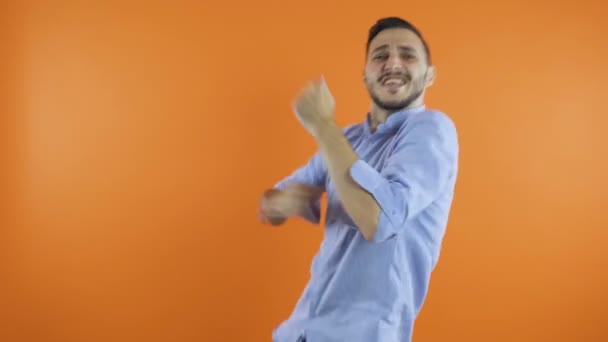 Expressive Energetic Young Man Dancing fast with hands listening music against background. Nyertes tánc koncepció - Felvétel, videó
