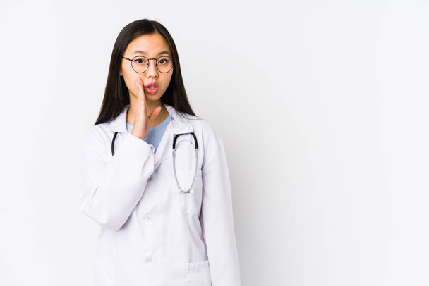 Νεαρή γιατρός Κινέζα γυναίκα απομονωμένη λέει ένα μυστικό καυτό φρένο ειδήσεις και κοιτάζοντας στην άκρη - Φωτογραφία, εικόνα