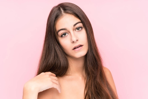 Young beauty caucasian woman against a pink background - Fotoğraf, Görsel