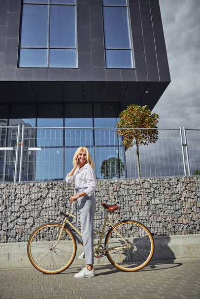 Şehirde bisikletle ekolojik araç kullanan güzel bir kadın resmi. - Fotoğraf, Görsel