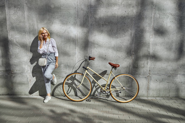 Güzel sarışın beyaz kadın boş şehir caddesinde güzel bir sonbahar havasının tadını çıkarıyor. - Fotoğraf, Görsel