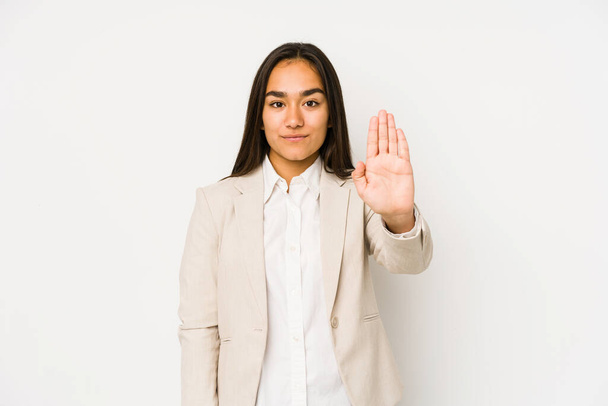 Jonge vrouw geïsoleerd op een witte achtergrond staan met uitgestrekte hand tonen stopteken, voorkomen dat u. - Foto, afbeelding