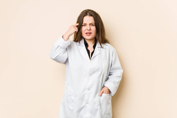 Νεαρή γιατρός γυναίκα δείχνει μια χειρονομία απογοήτευσης με δείκτη. - Φωτογραφία, εικόνα
