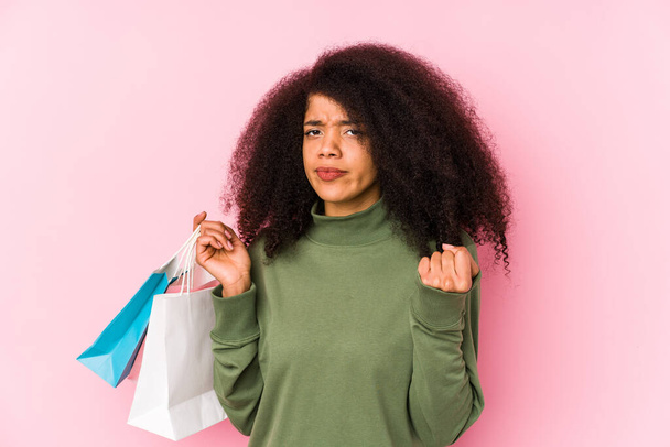 Young afro woman shopping isolated Young afro woman buying isolaYoung afro woman holding a roses isolated showing fist to camera, aggressive facial expression - Fotoğraf, Görsel