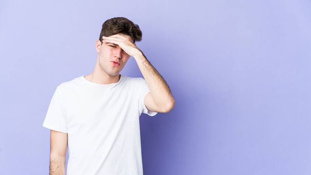 Young caucasian man isolated on purple background touching temples and having headache. - Photo, Image