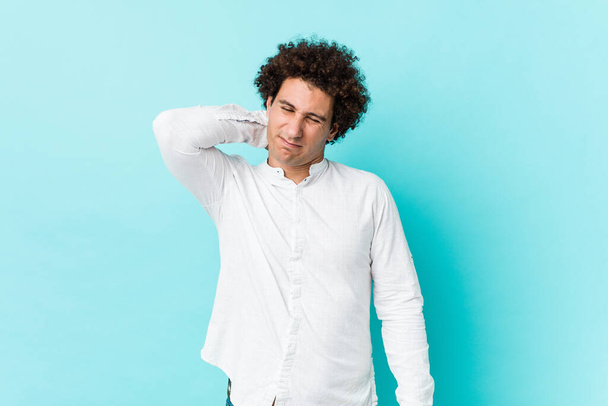 Jovem curly homem maduro vestindo uma camisa elegante sofrendo dor no pescoço devido ao estilo de vida sedentário. - Foto, Imagem