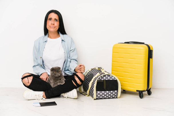 Traveler woman with her cat isolated on white background confused, feels doubtful and unsure. - Фото, изображение