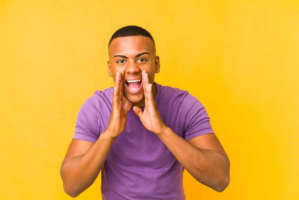 Young latin man isolated on yellow background shouting excited to front. - Photo, Image