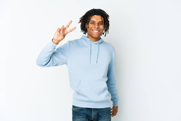 Joven rasta afroamericano alegre y despreocupado mostrando un símbolo de paz con los dedos. - Foto, Imagen