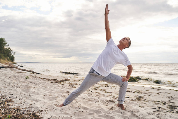 Sportieve man doet yoga training in de open lucht - Foto, afbeelding