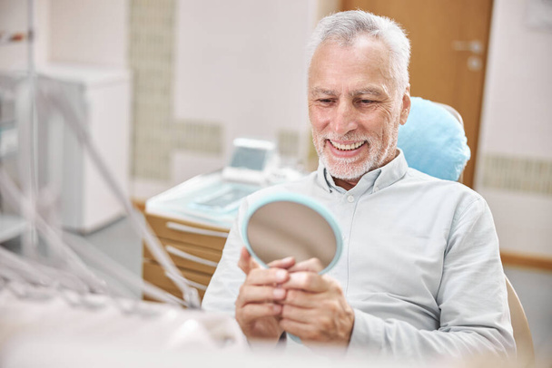 Aging gentleman sitting in a dental chair - Фото, зображення