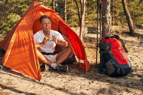Vidám ember kávét iszik sátorban fában - Fotó, kép