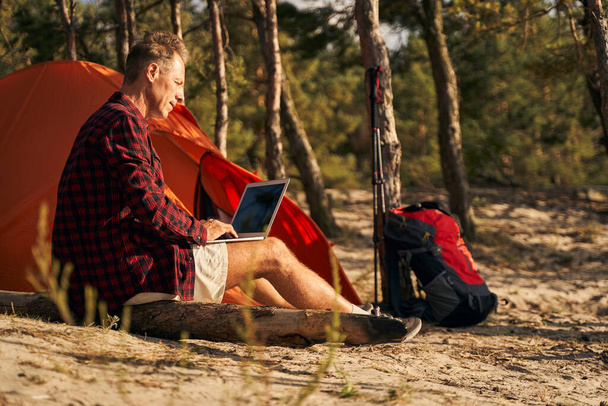 Hombre va de camping con cuaderno en el bosque - Foto, Imagen