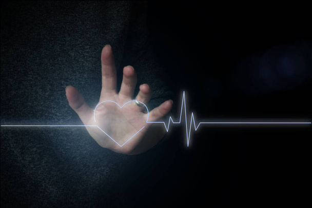 彼の手に心臓の手のタッチのホログラム。心臓移植、心臓病、脳卒中、医学の概念。心拍数デジタルタッチホログラムユーザーインターフェース技術コンセプト - 写真・画像