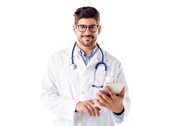 Portrait shot of smiling male doctor using digital tablet - Photo, image