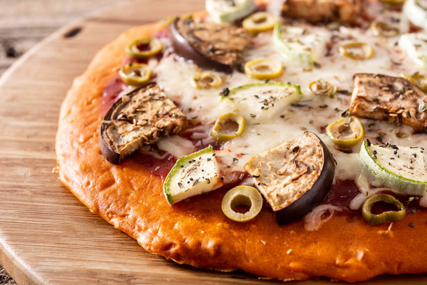 Pizza de calabaza de otoño con berenjena, calabacín, aceitunas y queso mozzarella sobre mesa de madera - Foto, Imagen
