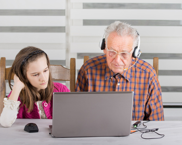 meisje en oude man op laptop - Foto, afbeelding