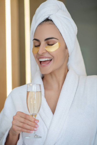 Headshot of pretty smiling girl with eye patches and glass of champagne - Foto, Imagem