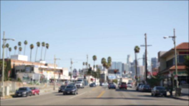 Los Angeles, Kaliforniya 'nın şehir merkezindeki caddelerde araba sürüyorum. Garaj yolundaki arabanın ön camından odaklı olmayan görüntü. Hollywood 'da araçları olan bulanık bir yol. Kamera otomobilin içinde, LA şehri estetiği.. - Fotoğraf, Görsel