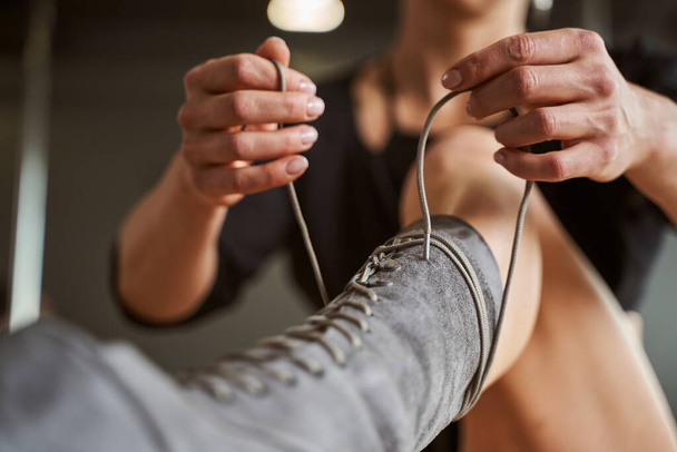 Woman hand tying shoes in fitness class - Foto, afbeelding