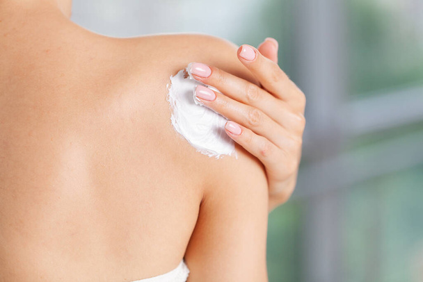 Huidverzorging, vrouw draagt vochtinbrengende crème op de huid - Foto, afbeelding