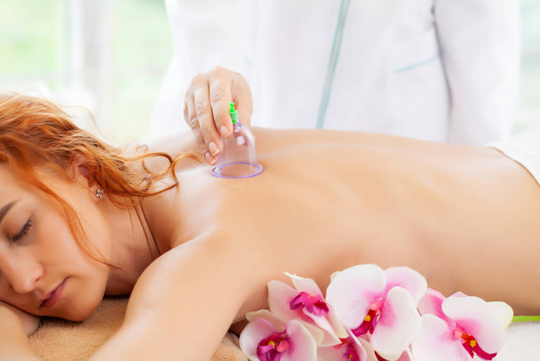 Schöne Frau entspannt sich im Wellness-Salon mit Vakuum-Körpermassage - Foto, Bild