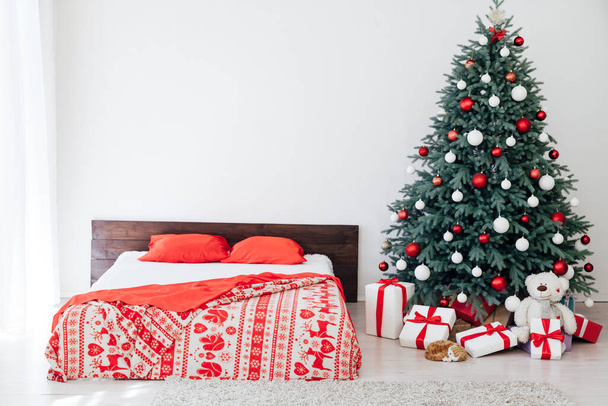 Interiér bílé ložnice s postelí s modrým vánočním stromečkem s červenými dárky na novoroční dekor zimní pohlednice - Fotografie, Obrázek